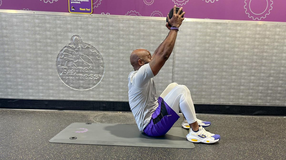 Teddy Savage performing a dumbbell sit-up Russian twist