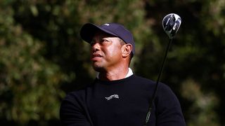 Tiger Woods strikes a three wood from the centre of the fairway