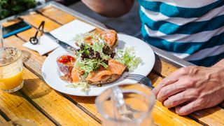 Man eating salmon with bread and salad