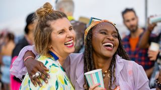 Two women smiling and dancing at a music festival