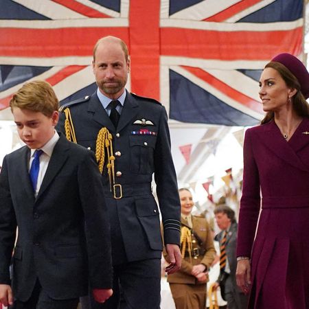 Prince George walking in front of Prince William and Prince Kate and a Union Jack flag