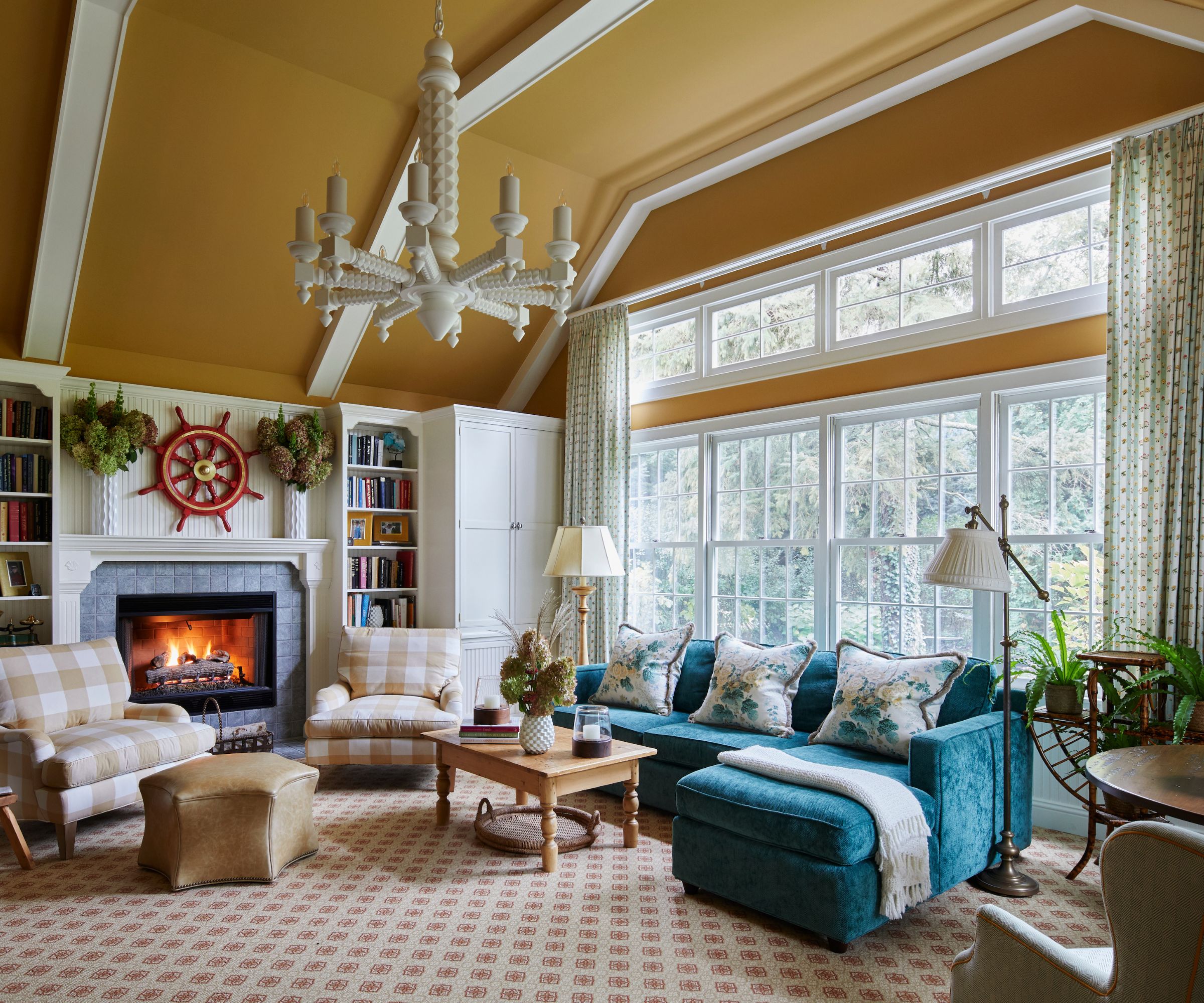 living room with yellow ceiling, white woodwork and trim, carpeted floor and large windows, teal sofa