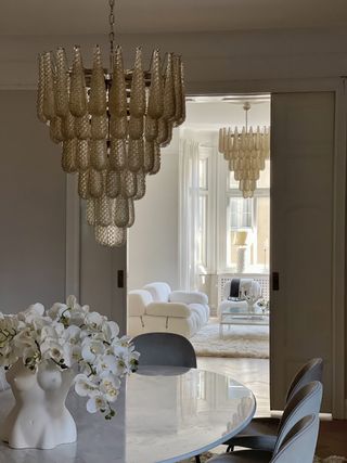 drop murano chandeliers in a dining room and living room