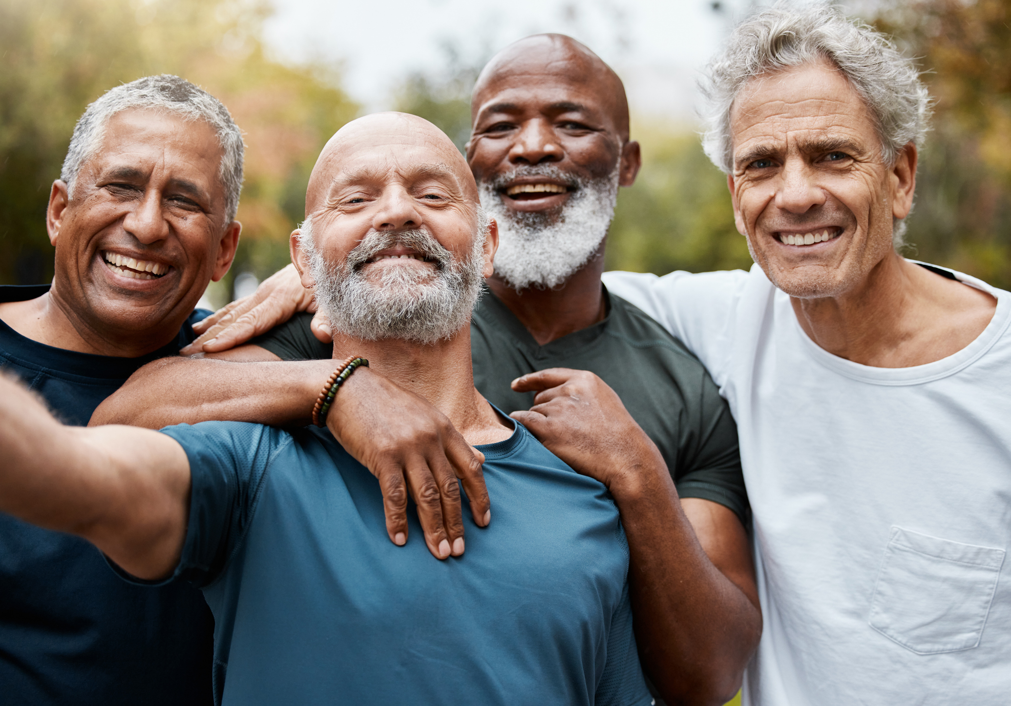 A group of older men pose for a selfie.