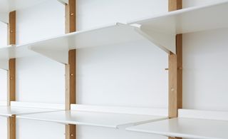 White shelf with brown frame on a white wall