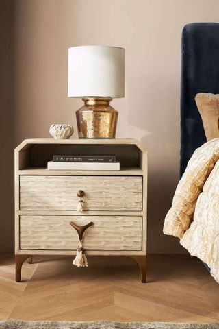 Zagora Tasseled Nightstand with tassel drawer pulls and styled with a metallic lamp on top