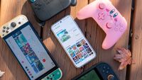 The Nintendo eShop Android app surrounded by Nintendo Switch controllers and a Switch 1 and 2