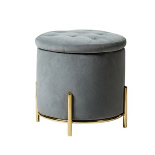 A gray circular storage ottoman with gold legs
