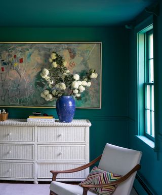 Bedroom with green painted wall and ceiling with armchair
