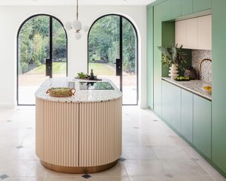 Modern kitchen with arch windows, rounded kitchen island, green cabinetry