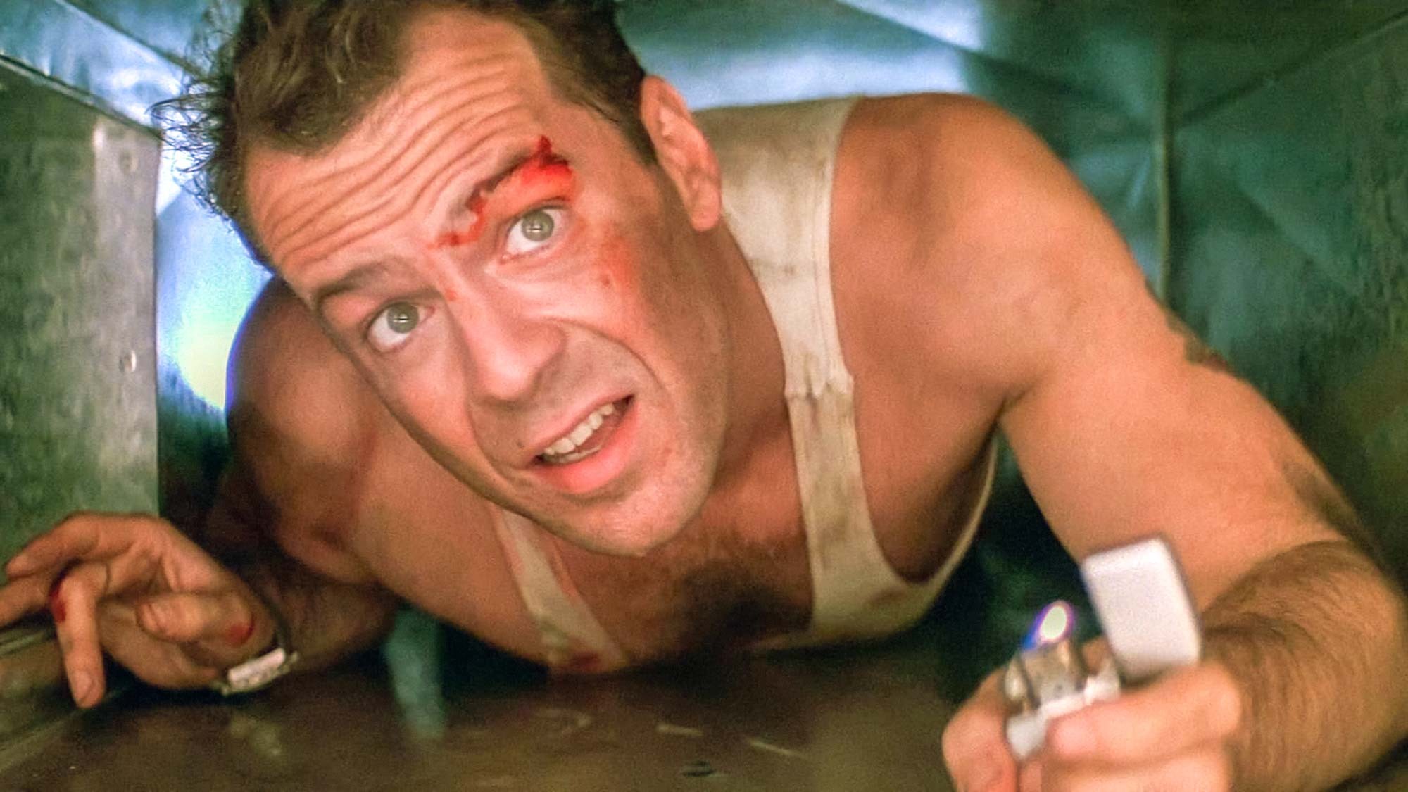 Bruce Willis (als John McClane) kriecht in einem Lüftungsschacht in Stirb langsam, einem Weihnachtsfilm