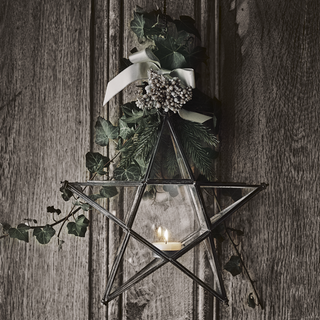 black door with star shape wreath and ivy