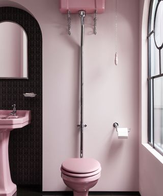 Pink bathroom scheme with pink toilet, sink and walls and black inset wall contrast