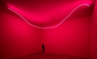 A red room with a neon U shaped light strip.