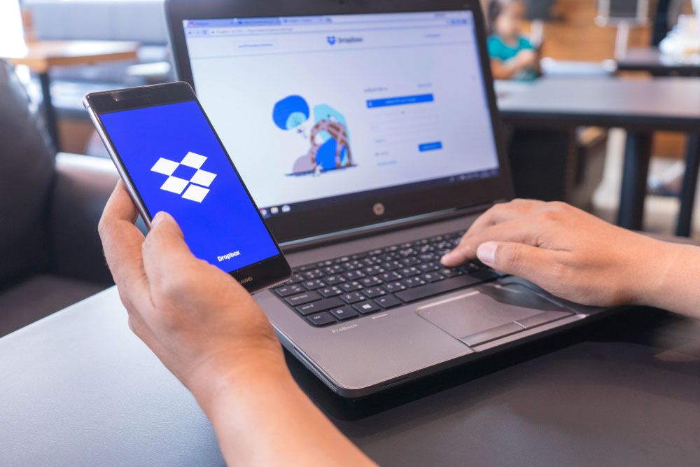 Dropbox open on both a smartphone and a Windows laptop.