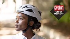 A woman is wearing a white bike helmet looking to the side