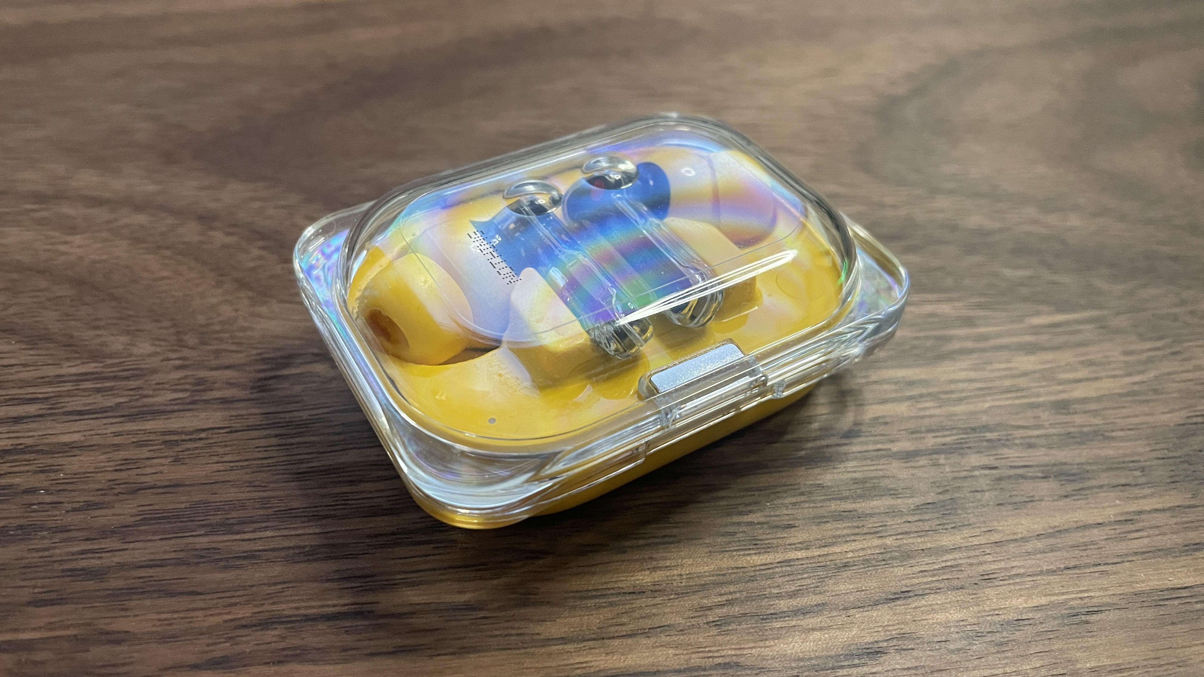Nothing Ear (a) earbuds in their charging case with the lid closed
