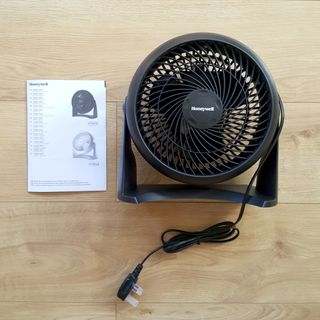 The black Honeywell Turbo Force Power fan on a wooden floor