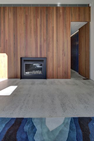 Upstairs, the timber clad walls provide a counterpoint to the glossy black exterior tiles and polished concrete floors