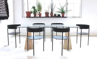 Glass topped table with wooden frame and six black chairs