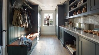 utility room with sink, cupboards, inbuilt dog bed, seating bench and coat hooks