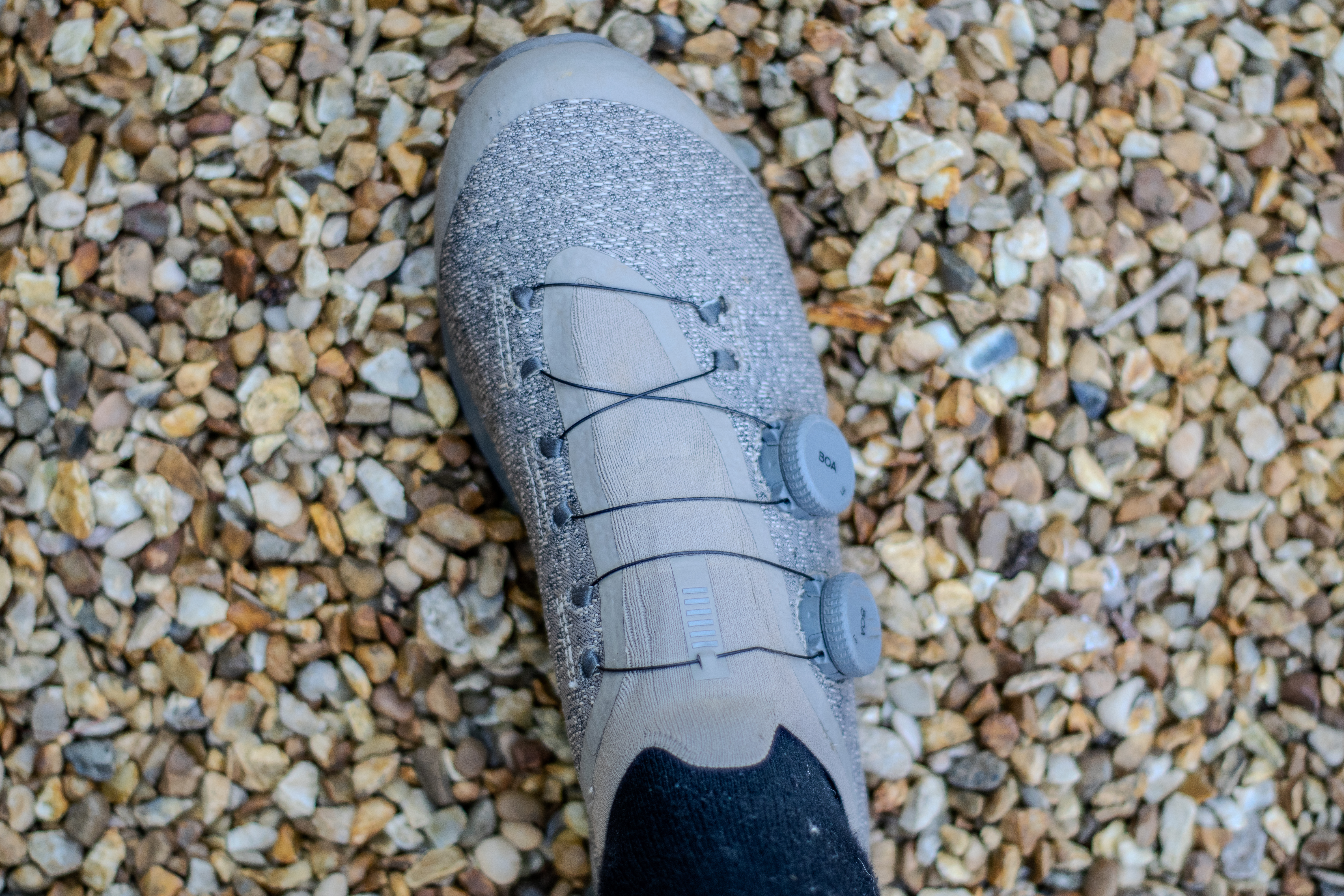 A pair of Rapha Pro Team Gravel shoes on some gravel
