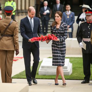 Kate Middleton and Prince William laying down a wreath of poppies during a visit to Manchester
