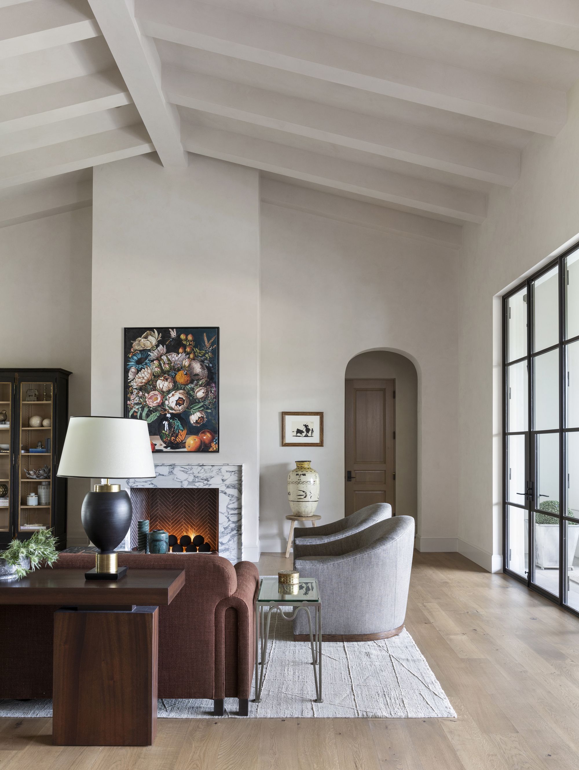 lime washed living area with timber beams and pitched ceiling