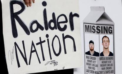 Fans hold signs with photographs of injured Las Vegas Raiders defensive end Maxx Crosby (98) and tight end Brock Bowers (89) before an NFL game against the New York Giants at Allegiant Stadium on Sunday, Dec. 28, 2025, in Las Vegas.