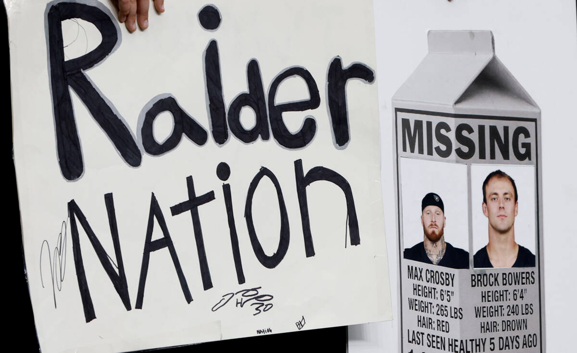 Fans hold signs with photographs of injured Las Vegas Raiders defensive end Maxx Crosby (98) and tight end Brock Bowers (89) before an NFL game against the New York Giants at Allegiant Stadium on Sunday, Dec. 28, 2025, in Las Vegas.