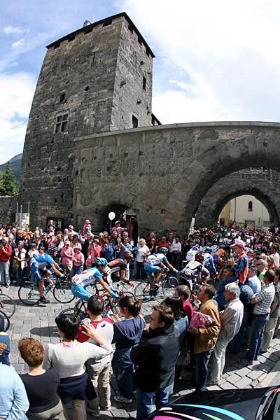 The peloton passes through an old city.