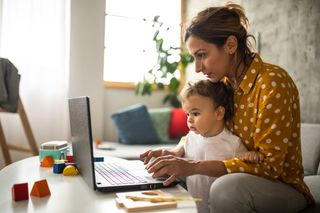 Mother trying to work from home while looking after her child