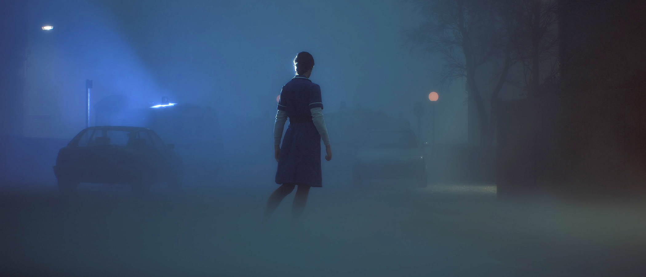 a nurse stands in a foggy street