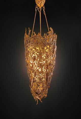 A bronze chandelier with various shapes sculpted into it.