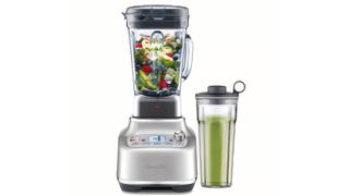 A Breville Super Q blender filled with fruit next to a personal jug