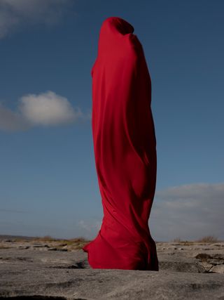 A person wrapped in red fabric.