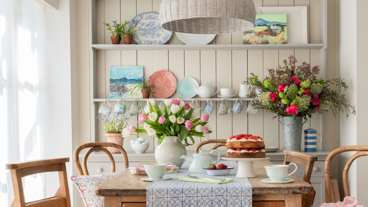 Flowers in vase on dining table, dinnerware set, displayed plates on shelves