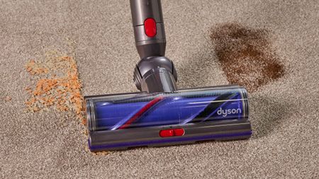 Vacuum cleaner floorhead with air intake slider, cleaning a carpeted floor