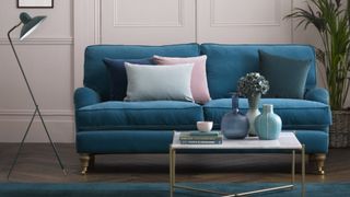 A blue velvet sofa bed in a period property
