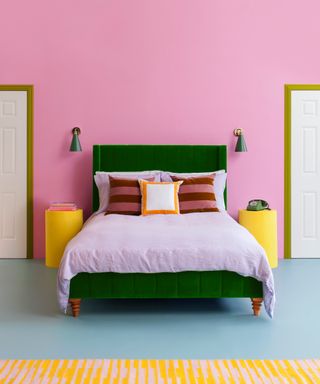 bright bedroom with green bed, pink walls and blue floor