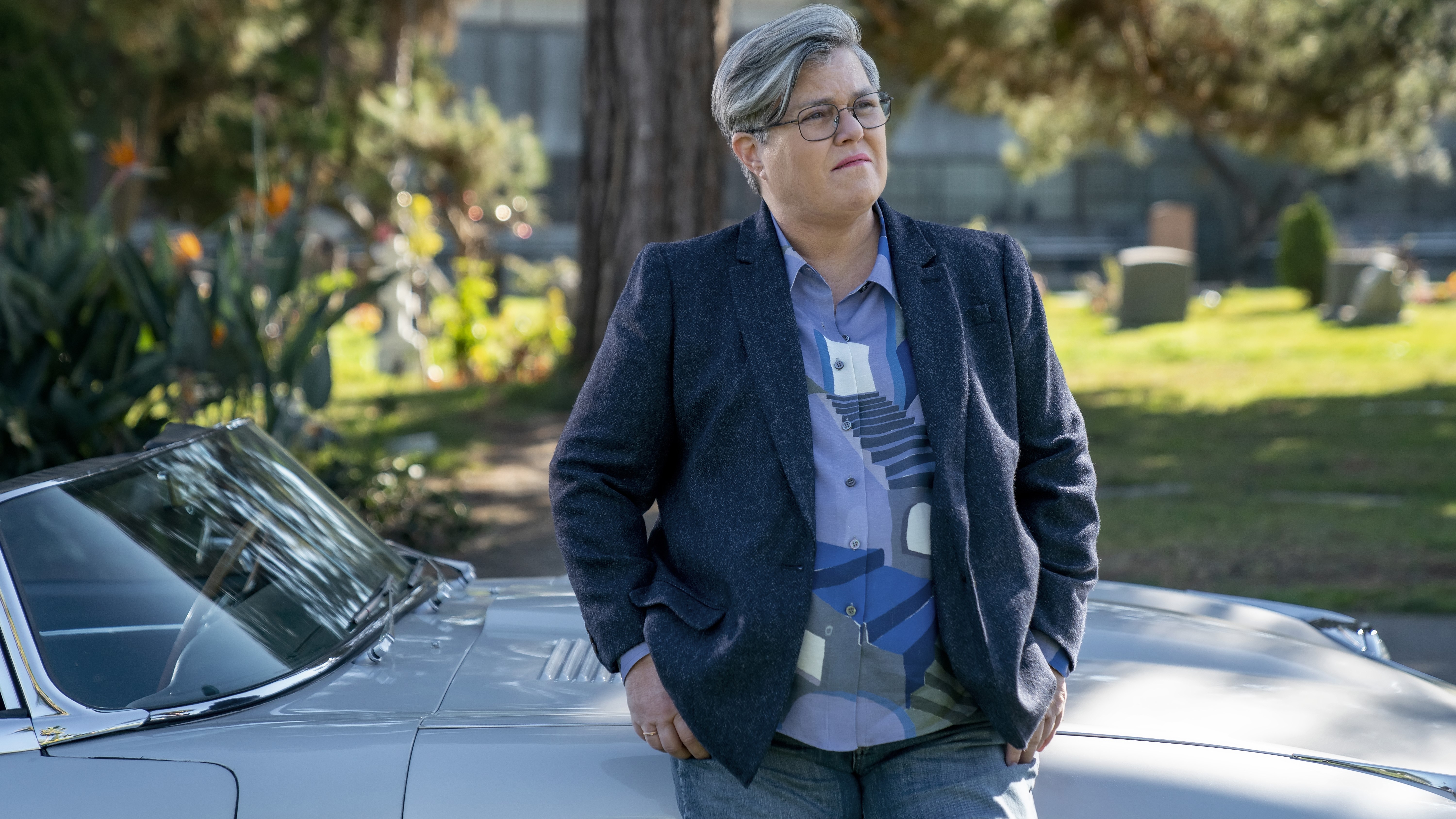 Rosie O'Donnell as Detective Sunday leaning on a car in American Gigolo