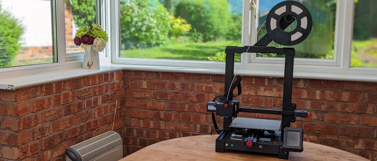 AnyCubic Kobra 3D printer surrounded by a garden