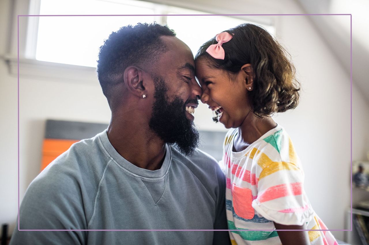 father and daughter laughing in bedroom