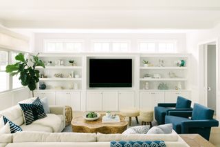 A living room with white walls and blue sofas