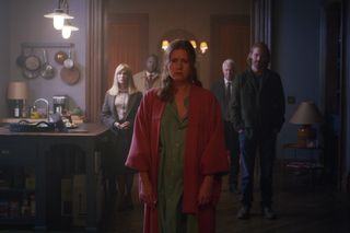 A distressed looking Anna (Amy Adams) stands facing the camera in her robe, with Jane (Jennifer Jason Leigh), Detective Little (Brian Tyree Henry), Alistair (Gary Oldman) and David (Wyatt Russell) standing some distance behind her