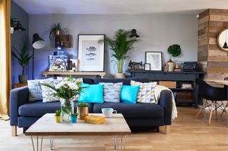 Spillett house: grey living room with grey-blue sofa, wood-effect floor, light grey walls, grey console table