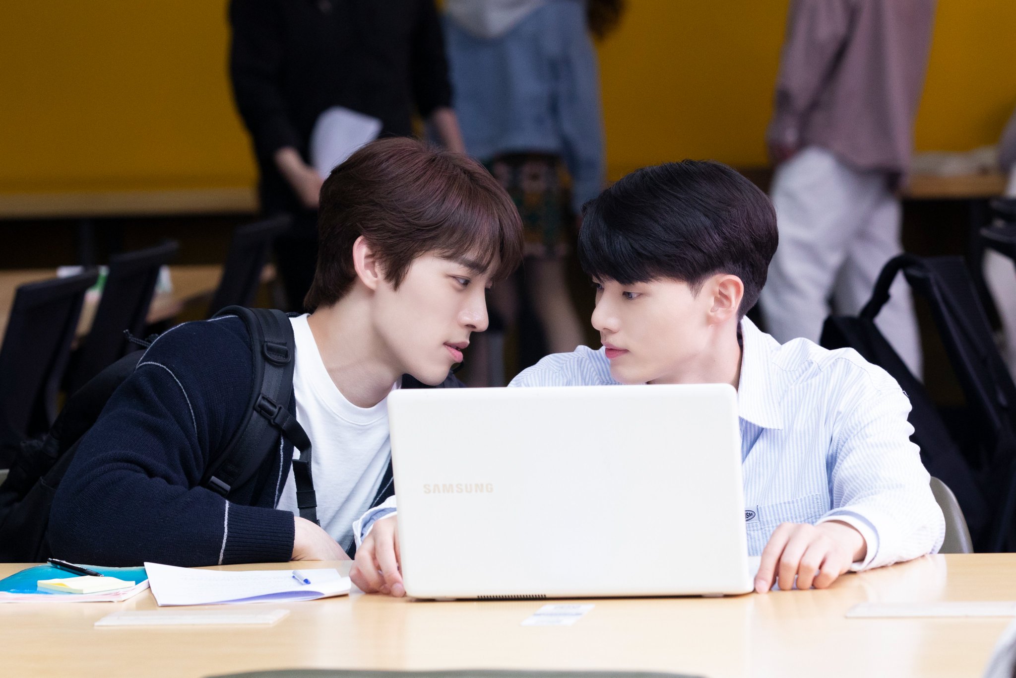 two boys sit at a desk looking at a laptop in a still from the bl kdrama blueming