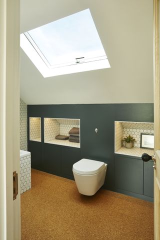 modern loft conversion bathroom with a blue wall and white fixtures photographed by fraser marr