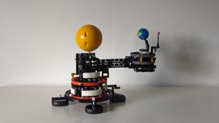 Lego technic planet earth and moon in orbit set on a white background