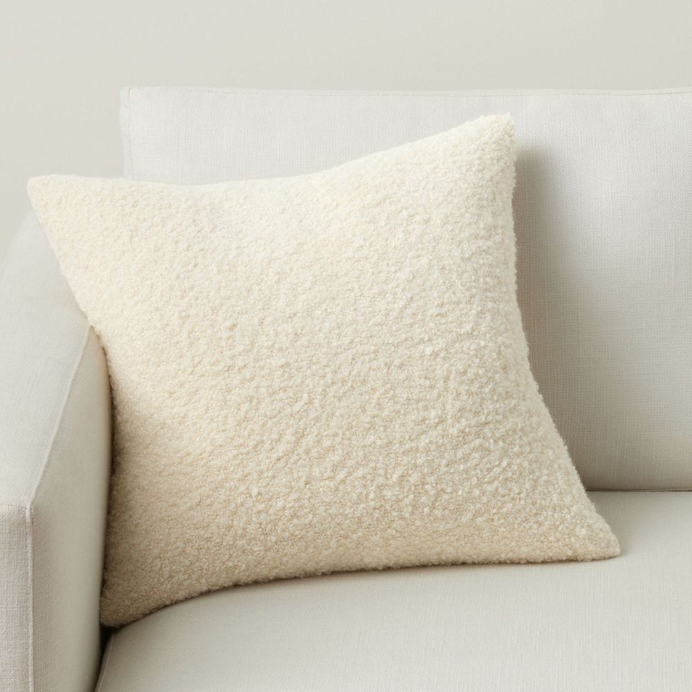 Cream boucle cushion on white armchair